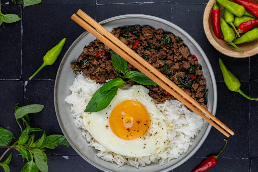 A mouth-watering dish of Thai basil beef served with rice and a perfectly fried egg.